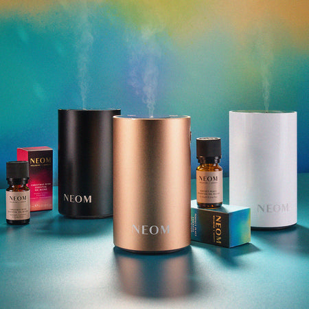 NEOM pod mini+ diffusers and essential oils on a gradient background
