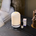 NEOM wellbeing pod and perfect nights sleep essential oil on a bedside table