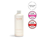 NEOM bath milk bottle with CEW and CFDA awards on a white background