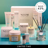 Collection of NEOM products including candles, bottles, and jars on a teal background. Save 43%.