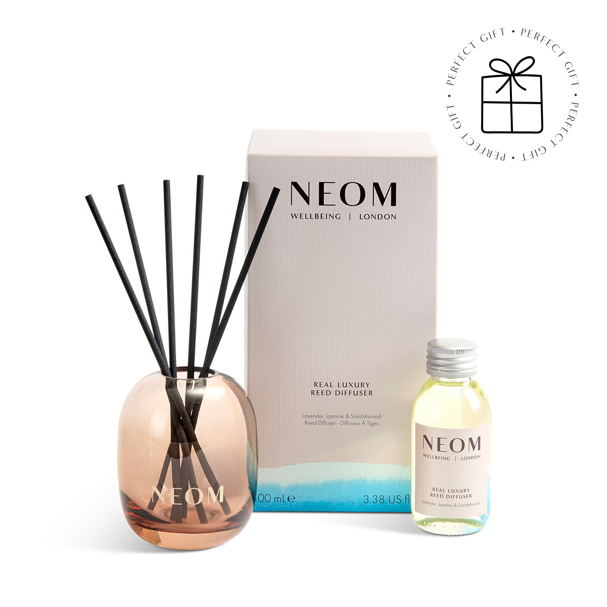 NEOM diffuser set with reeds and bottle on a white background with a Perfect Gift Roundel with a present