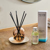 NEOM real luxury reed diffuser and box on a weaved table