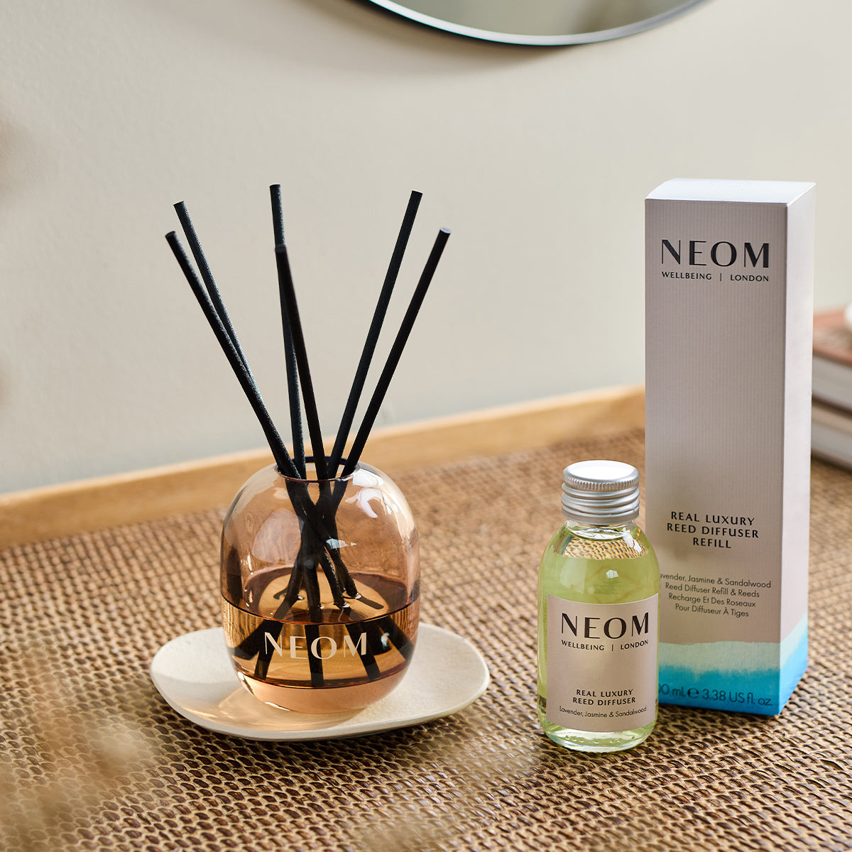 NEOM real luxury reed diffuser and box on a weaved table