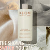 “NEOM Real Luxury Creamy Body Wash bottle over a collage of soft, calming textures. Text reads: ‘The shower to switch you off.’”