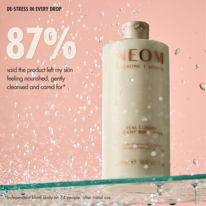 “NEOM Real Luxury Creamy Body Wash on a pink background with water splashes. Text reads: ‘De-stress in every drop. 87% said the product left my skin feeling nourished, gently cleansed and cared for*’. Small print: ‘*Independent blind study on 74 people, after initial use.’”