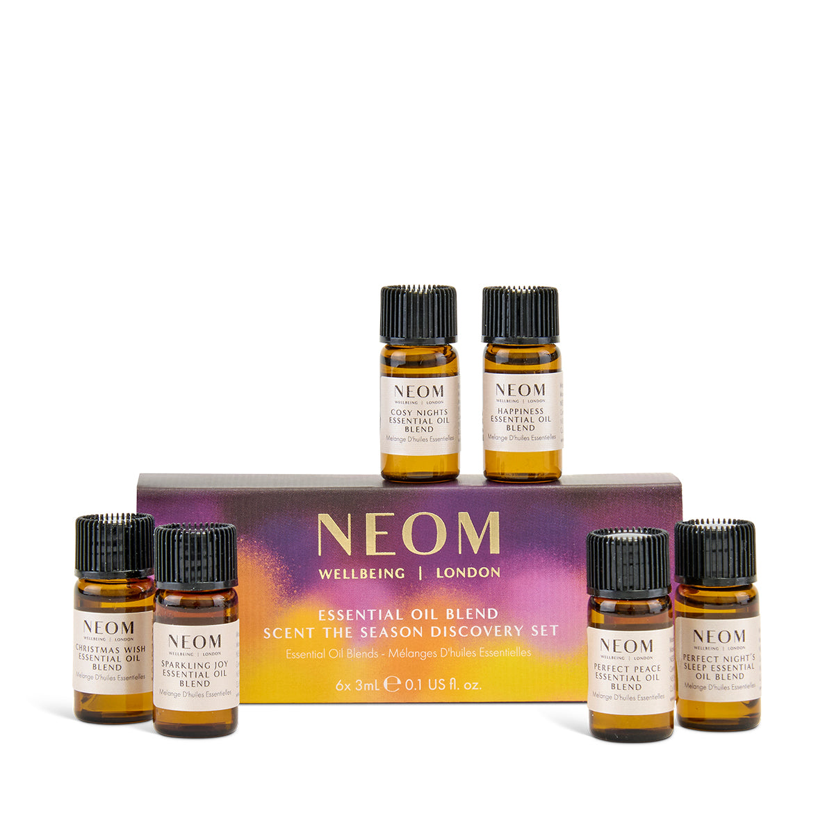 NEOM Christmas essential oil blend set with six small bottles in front of a box on a white background