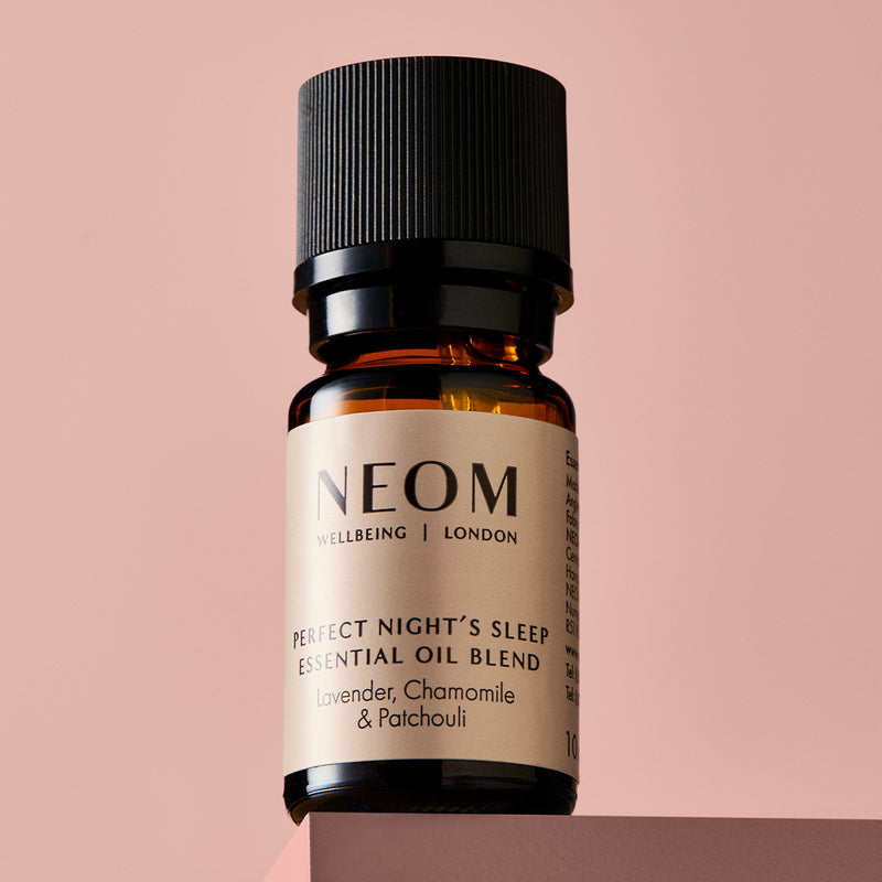 NEOM Perfect Night’s Sleep essential oil blend bottle on a pink background.