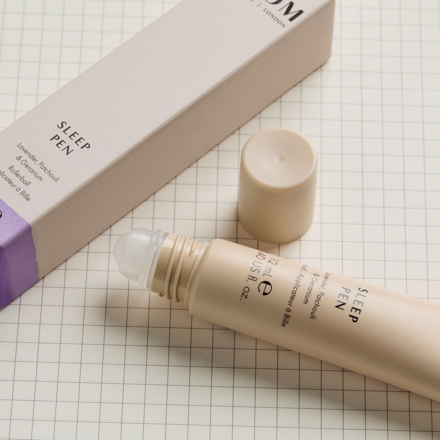 NEOM Sleep Pen product with packaging on a grid background