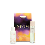 NEOM wellbeing products including bath foam and pillow mist with packaging on a white background