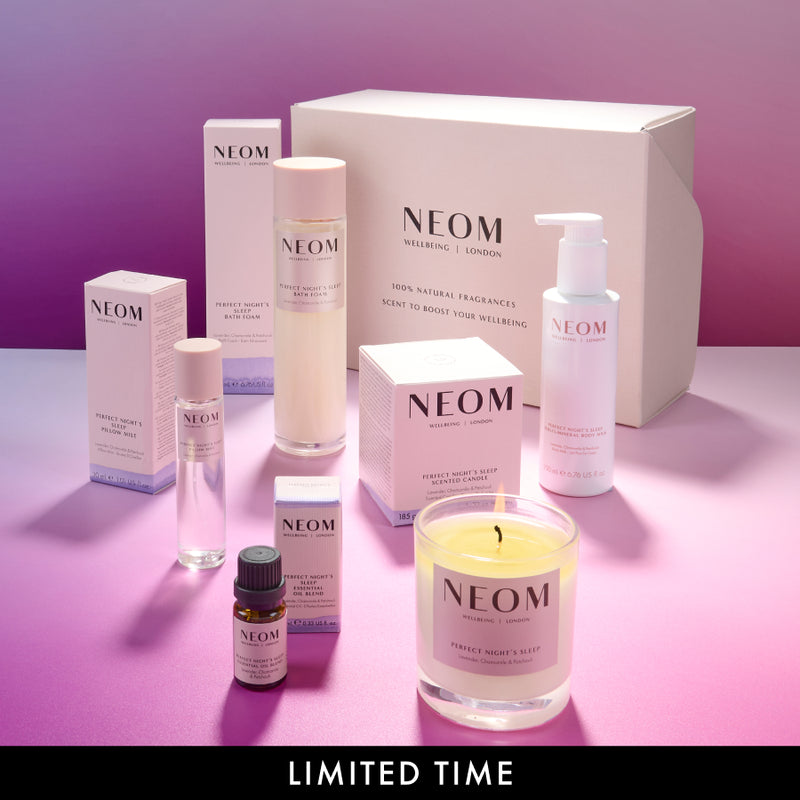 NEOM bath and body and wellness products on a pink background