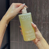 NEOM squeeze the day body wash being opened in the shower by a person