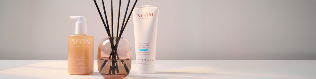 NEOM Hand Wash, Reed Diffuser and Body Butter on a neutral background