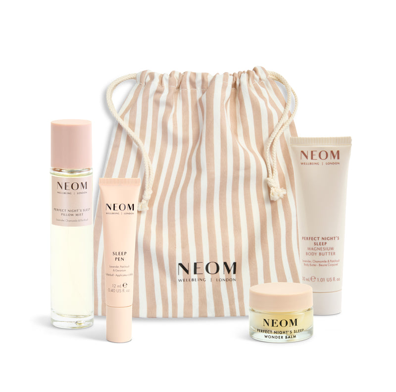 NEOM product set with a beige striped drawstring bag on a white background