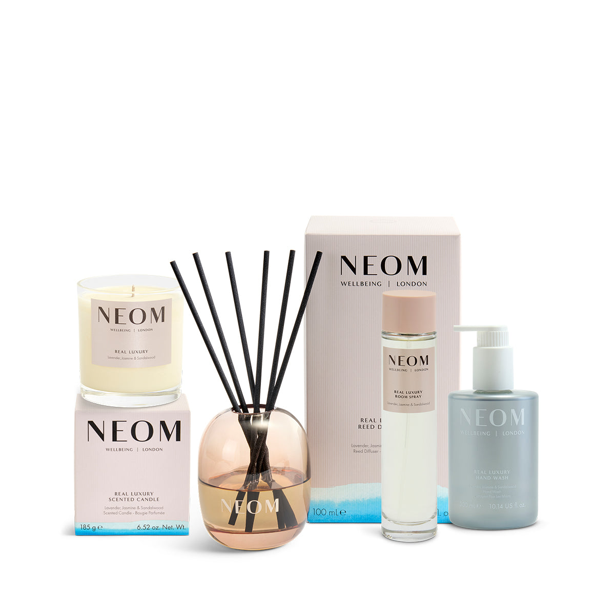 NEOM product set including a reed diffuser, candle, room spray and hand wash on a white background