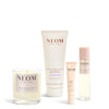 NEOM skincare products including a candle, tube, and bottles on a white background