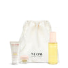 NEOM skincare products including a bottle, tube, and jar with a white drawstring bag on a white background.