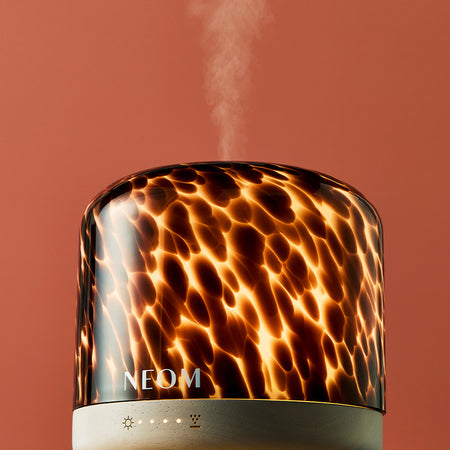 Leopard print NEOM limited edition electric pod luxe diffuser on a red background