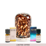 NEOM tortoiseshell pod diffuser and happiness essential oil blend and perfect peace essential oil blend with packaging on a white background
