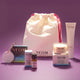 NEOM products with a drawstring bag on a purple background
