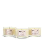 Three NEOM travel candles on a white background