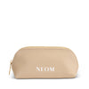 Gold cosmetic bag with 'NEOM' branding on a white background