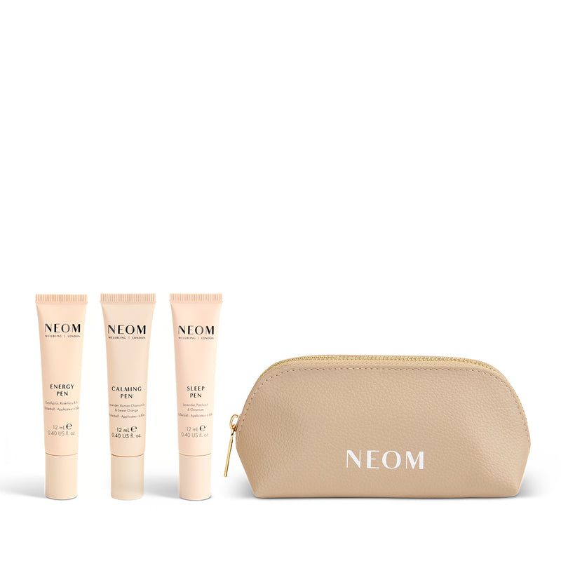 NEOM pen set with three pens and a gold pouch on a white background