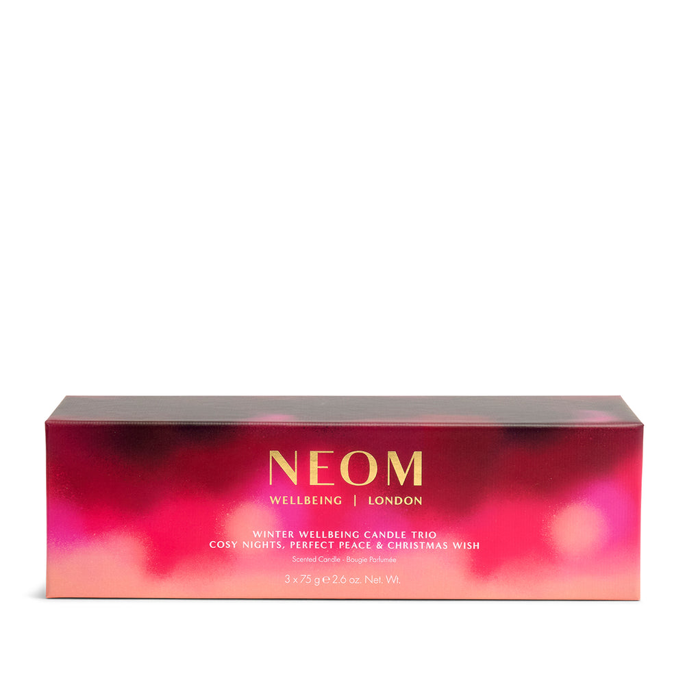 NEOM Winter Wellbeing Candle Trio packaging with a pink and red gradient on a white background