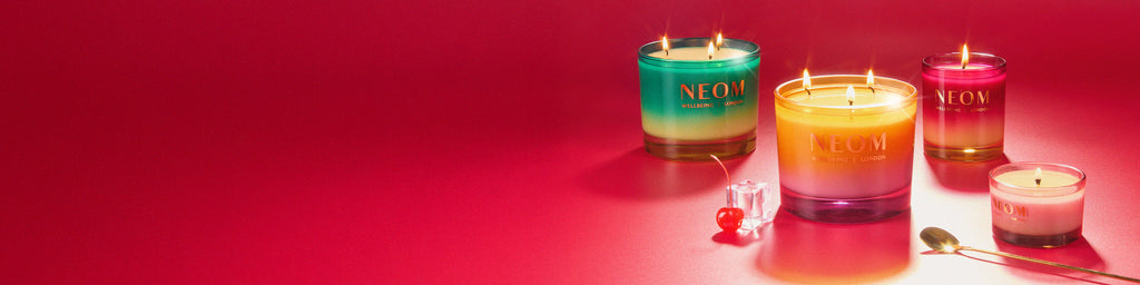 NEOM Christmas candles with gradient colours on a red background