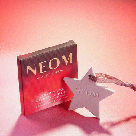 NEOM Ceramic Start Natural Diffuser with packaging on a red background 
