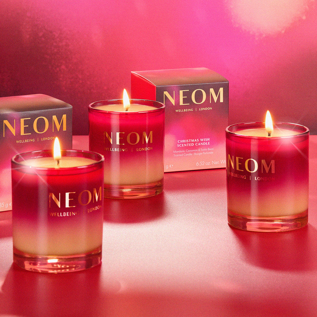 NEOM candles with a pink gradient on a red background