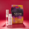 NEOM skincare products on a red background